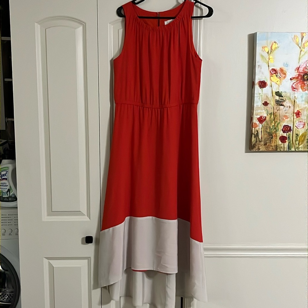 Long coral dress with a cream asymmetrical bottom hem.
